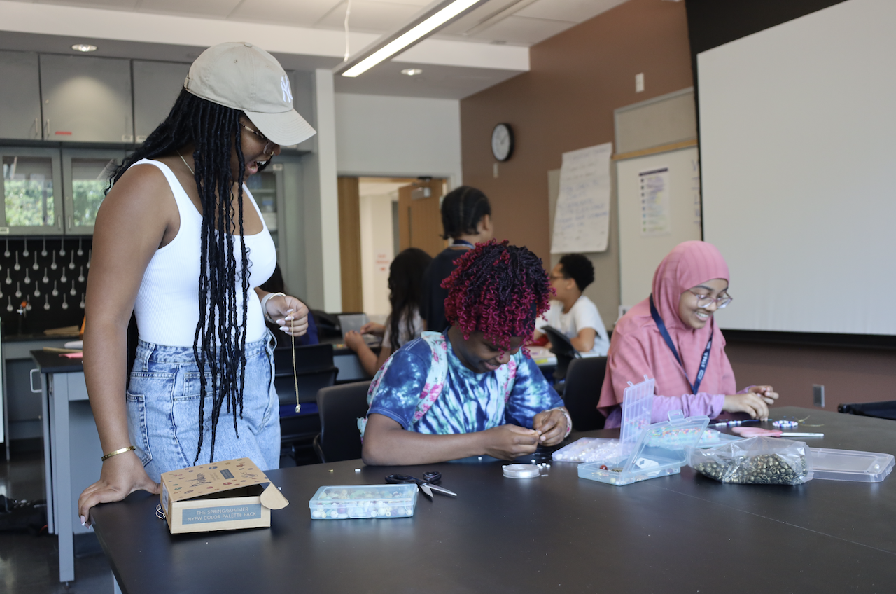 Counselor and students at a jewelry making workshop