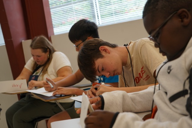 Students writing on a desk