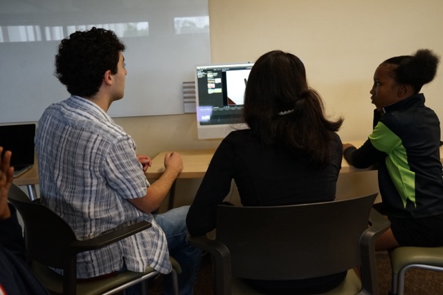 Students and an adult looking at a computer