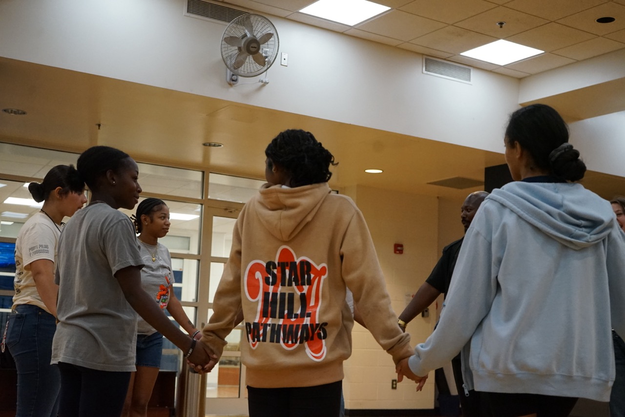 Students holding hands in a circle