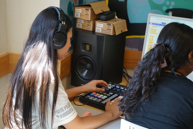 Students at a computer with headphones