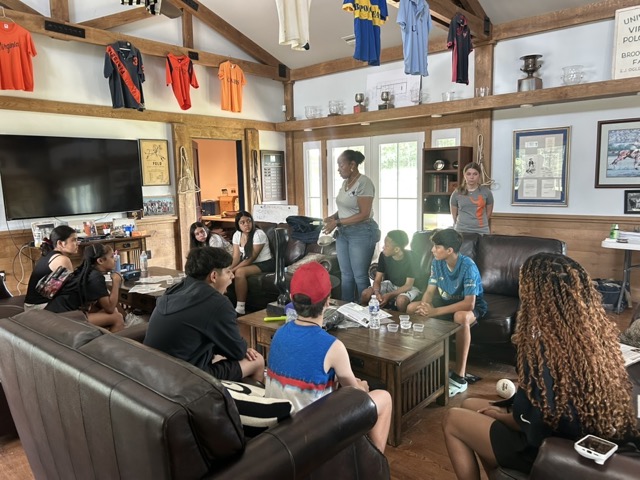 A woman standing and talking to sitting students