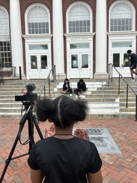 Students recording in front of a building