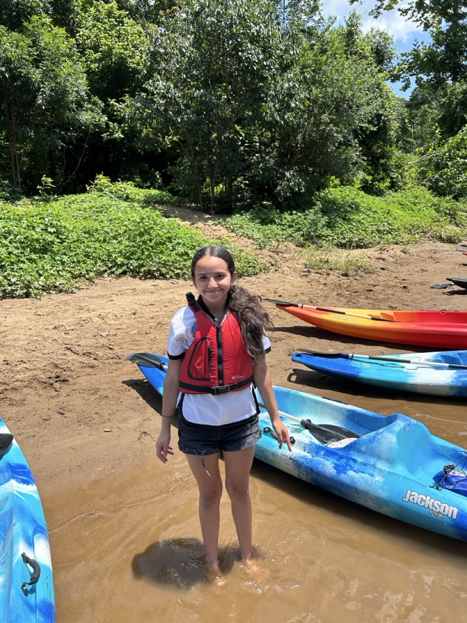 A student posing next to a canoe